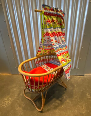 Rotan poppenwiegje met Stenzo kabouterstof. Verkocht.