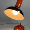 Brandende mid century oranje chroom burolamp met witte achtergrond