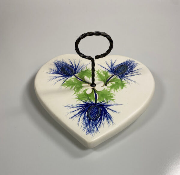 vintage presenteertableau plateel met 3 distels3 Vintage plateel presenteertableau met daarop 3 geschilderde distels, voorzien van ijzeren ring op steel als handgreep