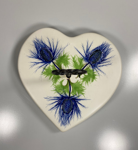 vintage presenteertableau plateel met 3 distels4 Van bovenaf gezien; Vintage plateel presenteertableau met daarop 3 geschilderde distels, voorzien van ijzeren ring op steel als handgreep